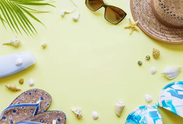 Seyahat Aksesuarları: sarı arka plan boşluk ile yeşil tropikal palmiye yaprağı, Flip-flop, Mayo, deniz ve güneş gözlüğü vardır. Üstten görünüm seyahat veya tatil kavramı, düz yatıyordu yaz arka plan