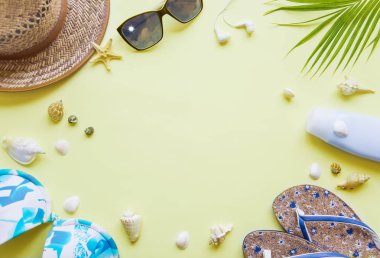 Seyahat Aksesuarları: sarı arka plan boşluk ile yeşil tropikal palmiye yaprağı, Flip-flop, Mayo, deniz ve güneş gözlüğü vardır. Üstten görünüm seyahat veya tatil kavramı, düz yatıyordu yaz arka plan
