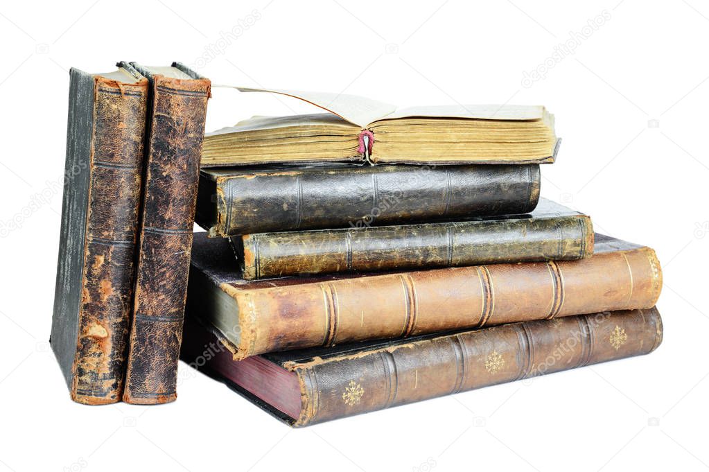 Open book lies on a pile of old books isolated on a white background