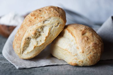 İki taze ev yapımı ekmek ciabatta eski ahşap Komiteler arka plan üzerinde gri kumaş peçete üzerinde. Ciabatta geleneği İtalyan fırın üründür