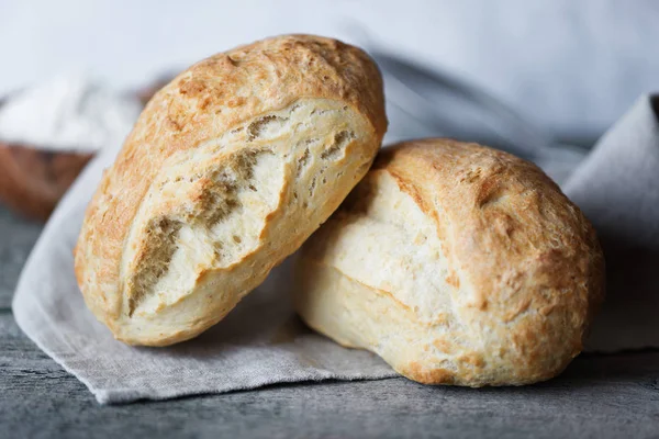 İki taze ev yapımı ekmek ciabatta eski ahşap Komiteler arka plan üzerinde gri kumaş peçete üzerinde. Ciabatta geleneği İtalyan fırın üründür