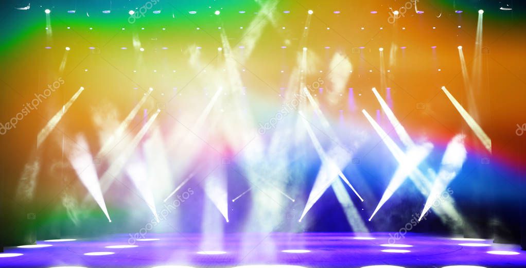 Illuminated free concert stage with haze and rays of multicolored light. Background for music show