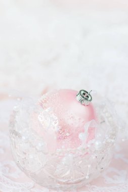 Güzel Noel dekorasyonu: bir büyük pembe Noel top beyaz bir şerit ve boşluk ile hafif bir arka plan üzerinde bir kristal vazo içinde inci