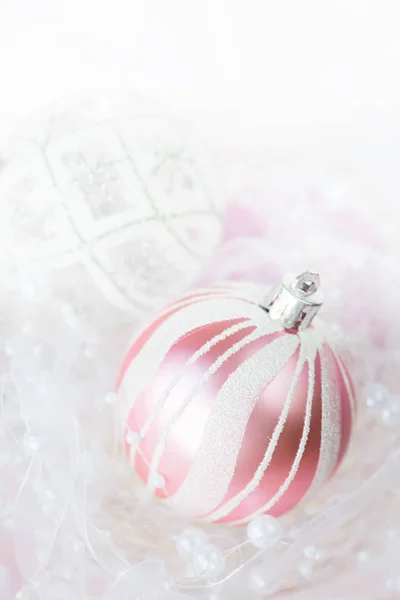 美丽的圣诞装饰白色和粉红色的颜色 几个圣诞球与白色丝带和珍珠在一个光的背景 与文本空间 — 图库照片