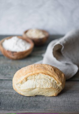 Gri kumaş peçete yalan arka plan eski ahşap kurulların üzerine taze el sanatları ekmek kaplı. Boşluk ile dikey görüntü