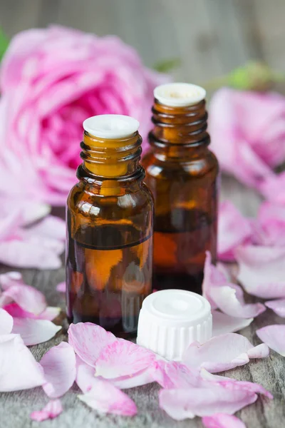 Two Dark Vials Rose Essential Oil Pink Roses Wooden Background — Stock Photo, Image