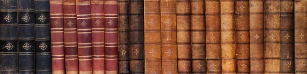 Long row of ancient books on shelf in the library
