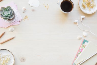 Kadın ev ofis resepsiyon masası pastel tonlarda. Dizüstü bilgisayarlar, fincan kahve ve boşluk ile ışık ahşap arka plan üzerinde süslemeleri ile çalışma alanı. Düz yatıyordu, en iyi görünümü