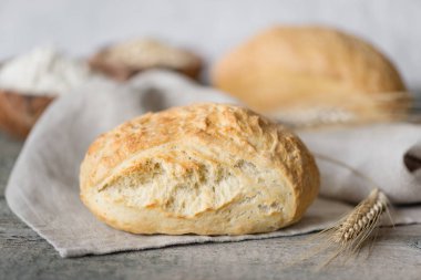 İki taze ev yapımı ekmek ciabatta ve buğday kazığa eski ahşap Komiteler arka plan üzerinde gri kumaş peçete. Ciabatta geleneği İtalyan fırın üründür