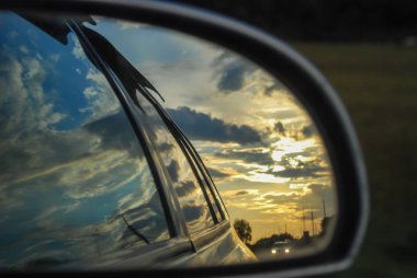 Güzel gün batımı arabayla seyahat dikiz aynasından yansıyan
