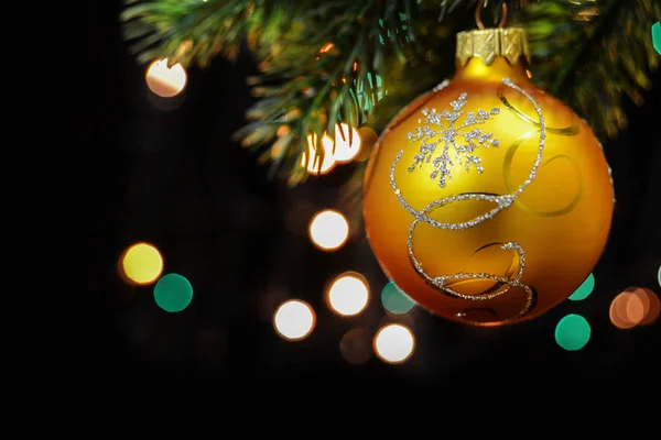 Hermosa composición navideña con una bola amarilla sobre un salvado de abeto — Foto de Stock