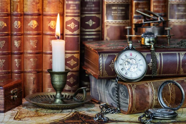 Pocket watch, burning candle and old books — Stock Photo, Image