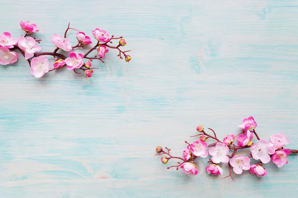 Fiori rosa su sfondo blu di legno — Foto Stock