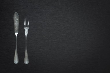 Cutlery for fish on a slate background clipart