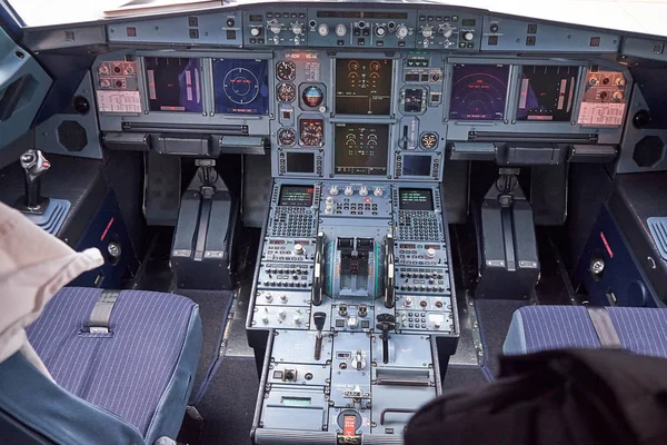 Interior view of pilot cabine in actual modern passenger jet airplane Airbus A319. Many buttons, navigation devices on dashboard. Aviation and transportation.