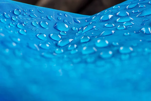 Water drops on waterproof nylon fabric. Nylon waterproof fabric with heavy blurred foreground and focused on the background water drops