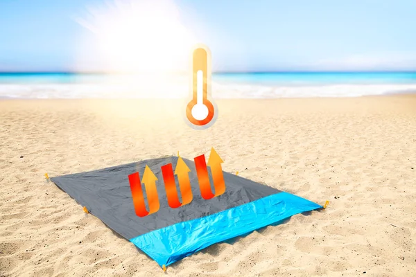 Heat deflective concept of high quality nykon fabric. Woven synthetic waterproof blue nylon clothing on a hot beach, on a sunny day, with termometer concept.