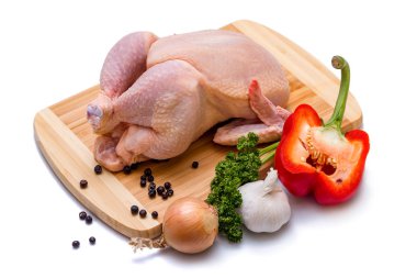 Tavuk karkas, yeşil maydanoz, soğan ve sarımsak beyaz zemin üzerinde bir gemide. Kırmızı uygulama ve karnabahar