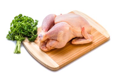 beyaz zemin üzerinde bir gemide Tavuk karkas ve yeşil maydanoz