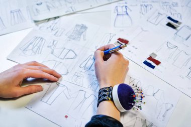 Atelier terzilik. çizim arka plan üzerinde eller. elinde bir tükenmez kalem kolunda iğne ile bir iğne bilezik