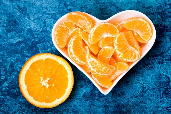 Mandarinenscheiben Und Eine Orange Einem Weißen Teller Herzform Auf Blauem — Stockfoto