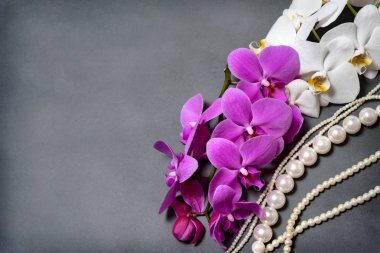 Orkide. Beyaz ve Pembe orkide dalı. İnci. Tebrik kartı. Güzel kompozisyon. Beyaz ve Pembe orkide gri bir arka plan ve inci boncuklar. Orkide buketi. Tropik çiçekler. egzotik.