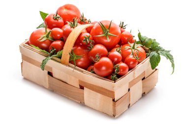 Farklı boyutlarda domatesler beyaz arka planda sepette.