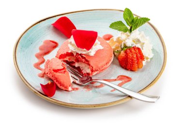 Mavi tabakta kremalı ve çilekli pembe tatlı.