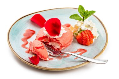 Mavi tabakta kremalı ve çilekli pembe tatlı.