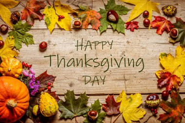 Şükran günün kutlu olsun. Ahşap bir arka planda balkabakları, akçaağaç yaprakları ve kestaneler. Tebrikler.