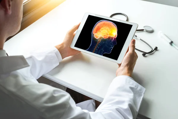 Doktor Röntgen beyin hastalığı dijital tablet izliyor. Migren ya da baş ağrısı kavramı