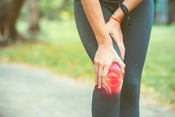 Mujer sosteniendo su rodilla con dolor rojo — Foto de Stock