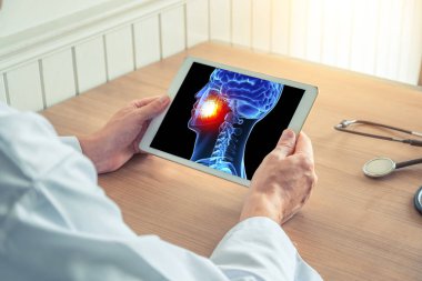 Doktor veya diş hekimi dişlerinde ağrı ile kafatası x-ray ile dijital bir tablet tutan