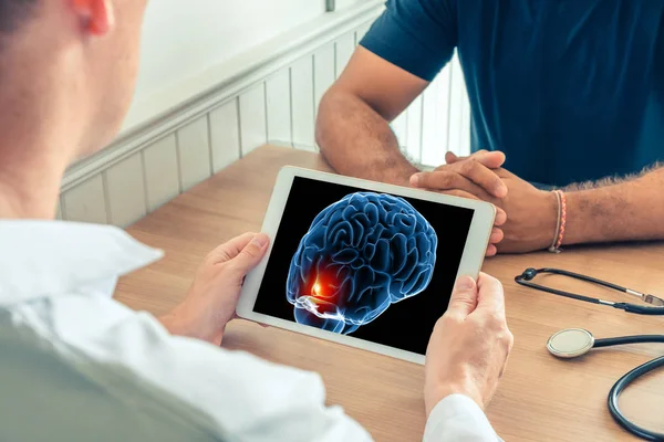 Doktor, önde ağrı olan hastanın 3 boyutlu beyninin röntgenini taşıyan dijital bir tablet tutuyor. Kanser baş ağrısı veya travma kavramı