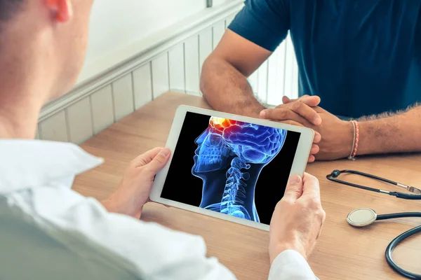 Doktor beynin önünde ağrı ile hastanın 3d başının x-ray ile bir dijital tablet tutan. Baş ağrısı kavramı