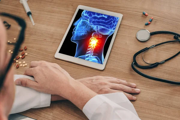 Doktor boynunda ağrı ile 3d kafatası kafası x-ray ile bir dijital tablet izliyor. Migren baş ağrısı veya travma kavramı