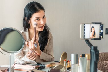 Online öğretim yapan kadın nasıl kurs yapılacağını öğretiyor. Akıllı telefonda video eğitimi kaydı