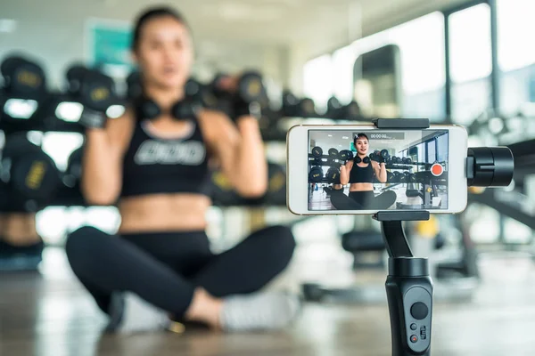 Mujer enseñando a hacer ejercicio en línea con un teléfono inteligente. Concepto Vlog — Foto de Stock