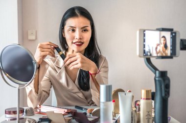 Nasıl makyaj öğretici için bir telefon ile Asyalı kadın kayıt. Çevrimiçi konsept sat
