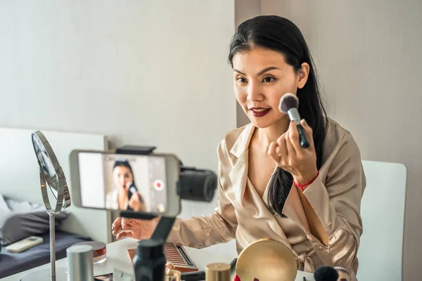 Mulher asiática bonita gravar um vídeo com telefone inteligente ao usar maquiagem para curso online. Tutorial de beleza — Fotografia de Stock