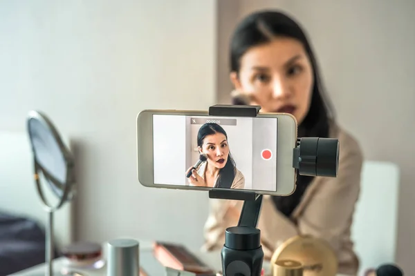 Asyalı bir kadın telefonla video kaydediyor. Nasıl makyaj öğretici online