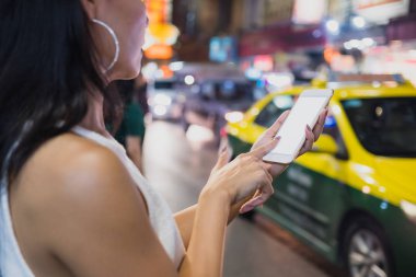 Sokakta telefon tutan Asyalı bir kadın. Telefonun ekranında boş