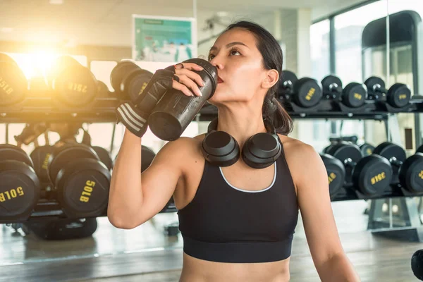 Mujer bebiendo durante el entrenamiento de fitness en el gimnasio. Concepto de hidratación — Foto de Stock