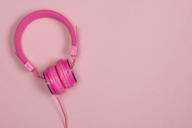 Kopyalama yeri olan pembe bir arka plan üzerinde pembe kulaklık