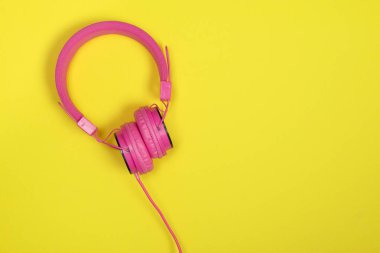 Sarı bir arka plan üzerinde pembe kulaklık