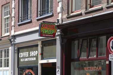 Amsterdam'da bir alışveriş caddesinde bir kahve dükkanı binası nın üzerinde Kahve dükkanı ışık marque logosu, orada yumuşak ilaçlar satışa sunulmuştur gösteren