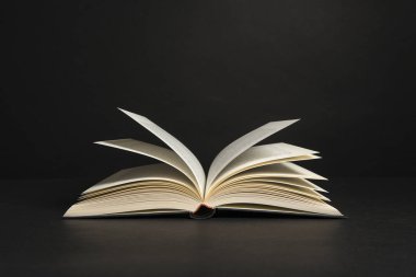 Siyah arka plan üzerinde sayfaları olan kitabı aç