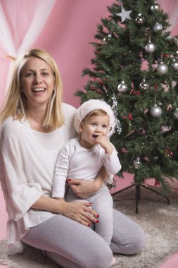 Noel ağacı tarafından poz bebek kızı ile Genç Anne