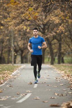 Gündüz açık koşan atletik genç adam