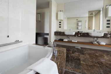Modern banyo iç çift lavabo ve büyük aynalar, banyo küveti, çini, görünümü penceresi ve havlu.